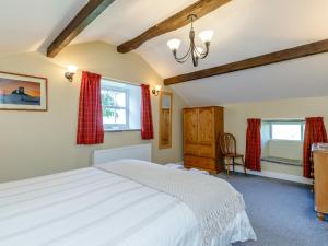 1 Schlafzimmer mit einem weißen Bett und 2 Fenstern in der Unterkunft Golden Slack Cottage in Allgreave