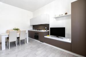 a kitchen with a dining table and a tv in a room at Giselle Apartments Maiori - Amalfi Coast in Maiori