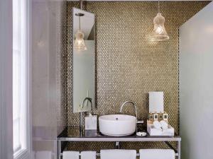 a bathroom with a sink and a mirror at Fable Auckland, MGallery in Auckland