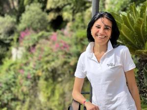 a woman in a white shirt standing in a garden at Due Relais - Panoramic Sea View Suites in Vietri