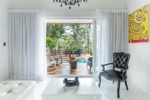 uma sala de estar com um sofá branco e uma cadeira em Gigi Brown Beachfront Santa Teresa em Santa Teresa