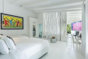 聖特雷莎海灘的住宿－Gigi Brown Beachfront Santa Teresa，一间白色的卧室,配有白色的床和一间餐厅