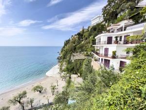 a building on a cliff next to a beach at Due Relais - Panoramic Sea View Suites in Vietri