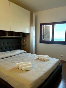1 dormitorio con 1 cama con 2 toallas en MiCasaEsTuCasa, en Porto Santo Stefano
