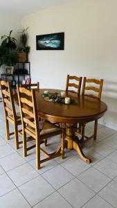 uma mesa de madeira com 4 cadeiras e uma sala de jantar em Maison cosy et nature pour 6 personnes em Lannilis