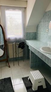 uma casa de banho com um lavatório e uma grande janela em Maison cosy et nature pour 6 personnes em Lannilis