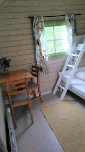 a room with a desk and a table and a bunk bed at Lilla mysstuga i havsnära in Varberg