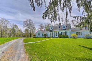 uma casa azul num relvado verde com uma estrada de terra em Quaint Woodstock Escape - 2 Mi to Tinker St! em Woodstock