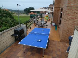 una mesa de ping pong azul en el patio en Con vistas al mar y aparcamiento gratis, en Suances