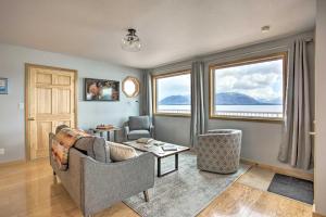 uma sala de estar com um sofá, 2 cadeiras e janelas em Remote Island Escape with Breathtaking Views 