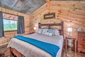 ein Schlafzimmer mit einem Bett in einem Blockhaus in der Unterkunft Updated Studio Cabin in Ozark - Mountain View in Ozark