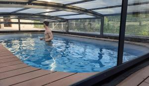 a man in a swimming pool in a building at CASA SAPEIRÓ - Allotjament Rural in Cellers