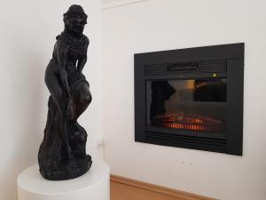 a statue of a woman standing in front of a fireplace at Apartment am Südpark Erfurt in Erfurt