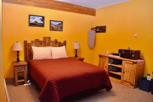 a bedroom with a bed in a yellow room at The Ouray Main Street Inn in Ouray