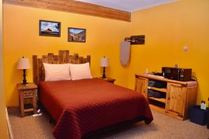 ein Schlafzimmer mit einem Bett in einem gelben Zimmer in der Unterkunft The Ouray Main Street Inn in Ouray