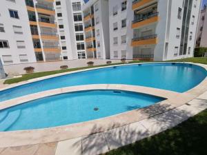 een groot blauw zwembad voor sommige gebouwen bij Happy Dreams Mar Salgado in Armação de Pêra