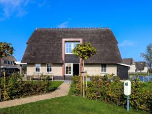 una casa con techo de paja en Beautiful villa with sauna on the Tjeukemeer, en Delfstrahuizen