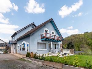 a blue house with a balcony on it at Large holiday home in Mimbach with private garden in Ditscheid