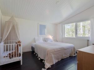 een slaapkamer met een bed en een wieg erin bij Spacious holiday home in Kamperland with garden in Kamperland