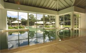 ein leeres Haus mit einem Pool mit Sonnenschirmen in der Unterkunft Green Park Solanas 2 ambientes en PB Excelente vista in Punta del Este