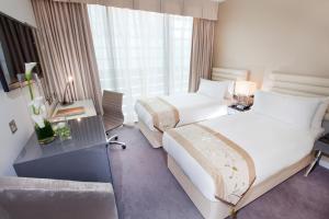 a hotel room with two beds and a window at Dorsett Shepherds Bush London in London