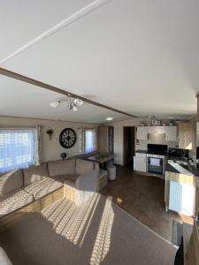 a living room with a couch and a kitchen at Dream place “Noah’sHope” in Leysdown-on-Sea