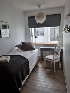 a bedroom with a bed and a chair and a table at Sogavegur 103 in Reykjavík