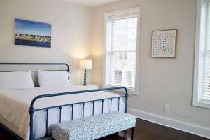 a bedroom with a bed and a chair and windows at Riverwalk 118 - River & Battleship Views in Wilmington