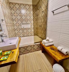 a bathroom with a sink and a bathtub and a bench at Empório reserva da serra com área lazer natureza e excelente localização in Campos do Jordão