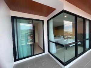 a balcony with glass windows and a view of a city at The Vita Plus Hotel in Hat Yai