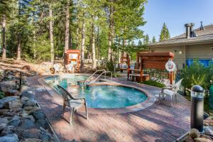 a swimming pool with chairs and a piano in a yard at Ski-In, Ski-Out Designer Condo in Truckee