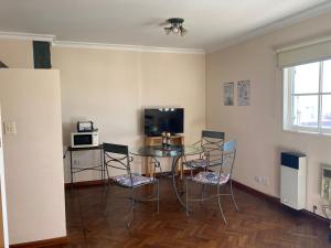 Un comedor con una mesa de cristal y sillas. en Departamento Mayoral, en Salta