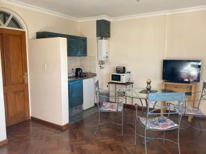 una pequeña cocina con mesa y sillas en una habitación en Departamento Mayoral, en Salta