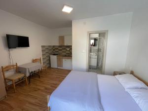 a bedroom with two beds and a kitchen with a table at Apartments Dionis in Kotor