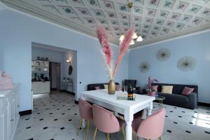 sala de estar con mesa blanca y sillas rosas en Casa Garibalda - seafronf apartment en Rapallo