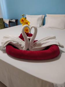 um par de cisnes feitos de toalhas numa cama em Diamantina Palace Hotel em Morro do Chapéu