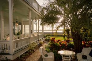 a porch of a house with chairs and a table at Bayfront Westcott House Bed & Breakfast in St. Augustine