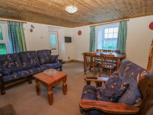 uma sala de estar com um sofá azul e uma mesa em Gortagown Cottage em Sneem