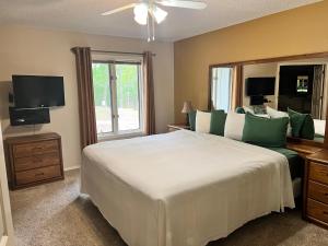 - une chambre avec un grand lit blanc et une fenêtre dans l'établissement Golfside Vacation Home 1, à Bella Vista