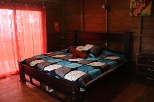 a bedroom with a bed in a wooden room at Eco Granja Don Lolo in Quesada