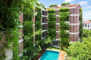 an apartment building with a vertical garden at Mulberry Collection Silk Eco in Hoi An