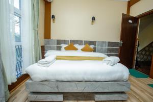 a bedroom with two beds with white sheets and orange pillows at Gauri Shankar Hotel Nagarkot in Nagarkot