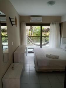 een slaapkamer met een bed en een groot raam bij Nas areias de Ponta Negra - Araça-309 in Natal