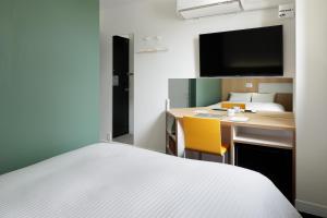 ein Hotelzimmer mit einem Bett und einem Schreibtisch mit einem Computer in der Unterkunft Kamishihoro Hotel in Kami-shihoro