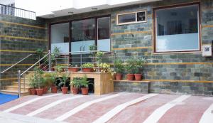 a building with a bunch of potted plants on it at Hotel Holiday Home in Jaipur