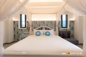 ein Schlafzimmer mit einem großen weißen Bett mit zwei Kissen in der Unterkunft Happiness is coming(Near Hualien Railway Station) in Hualien