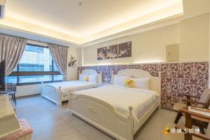 a bedroom with two beds in a room at 幸福來了-近花蓮火車站 寵物友善 電梯民宿 in Hualien City