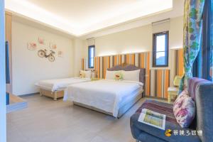 a hotel room with two beds and a couch at 幸福來了-免費車位 電梯 寵物友善 近花蓮火車站 in Hualien City