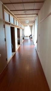 un pasillo vacío de un edificio de oficinas con suelo de madera dura en 農家民宿　たなか, en Suzu