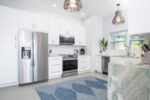 a kitchen with white cabinets and a stainless steel refrigerator at Luxury Villa, Pool, Ocean view, 3 separate Villas one Property, 5 Bedrooms in St Thomas